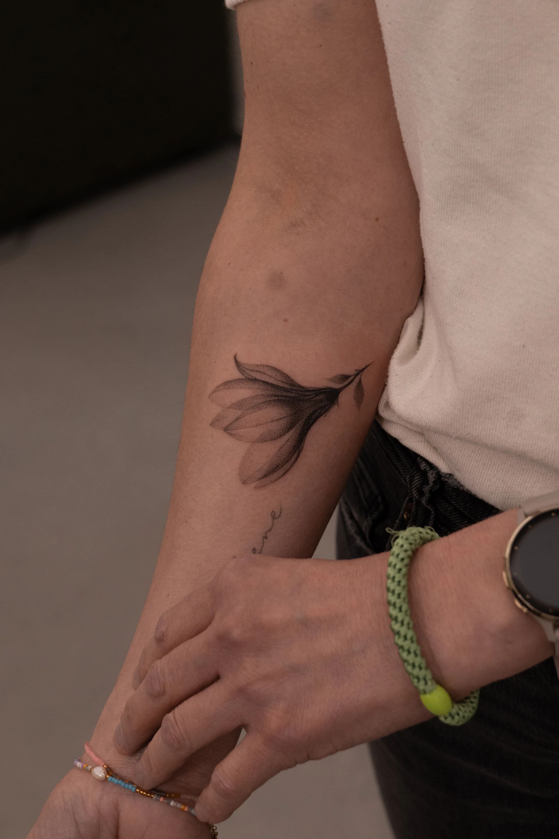 Delicate botanical handpoke tattoo on the forearm by Maria Pokes